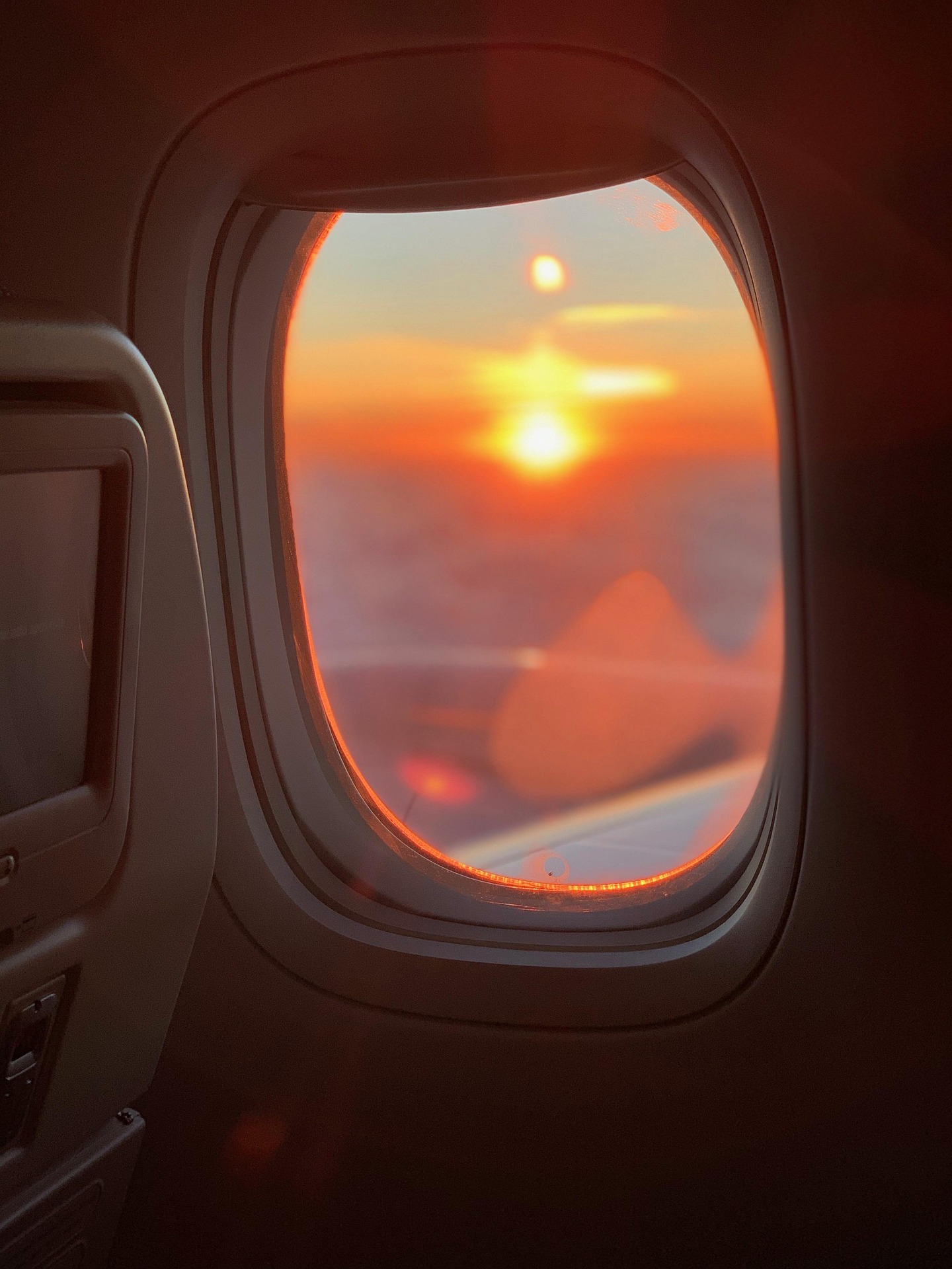 Uçak penceresinden gün batımı ve gökyüzü, sefer sırasında güzel doğa manzarası.