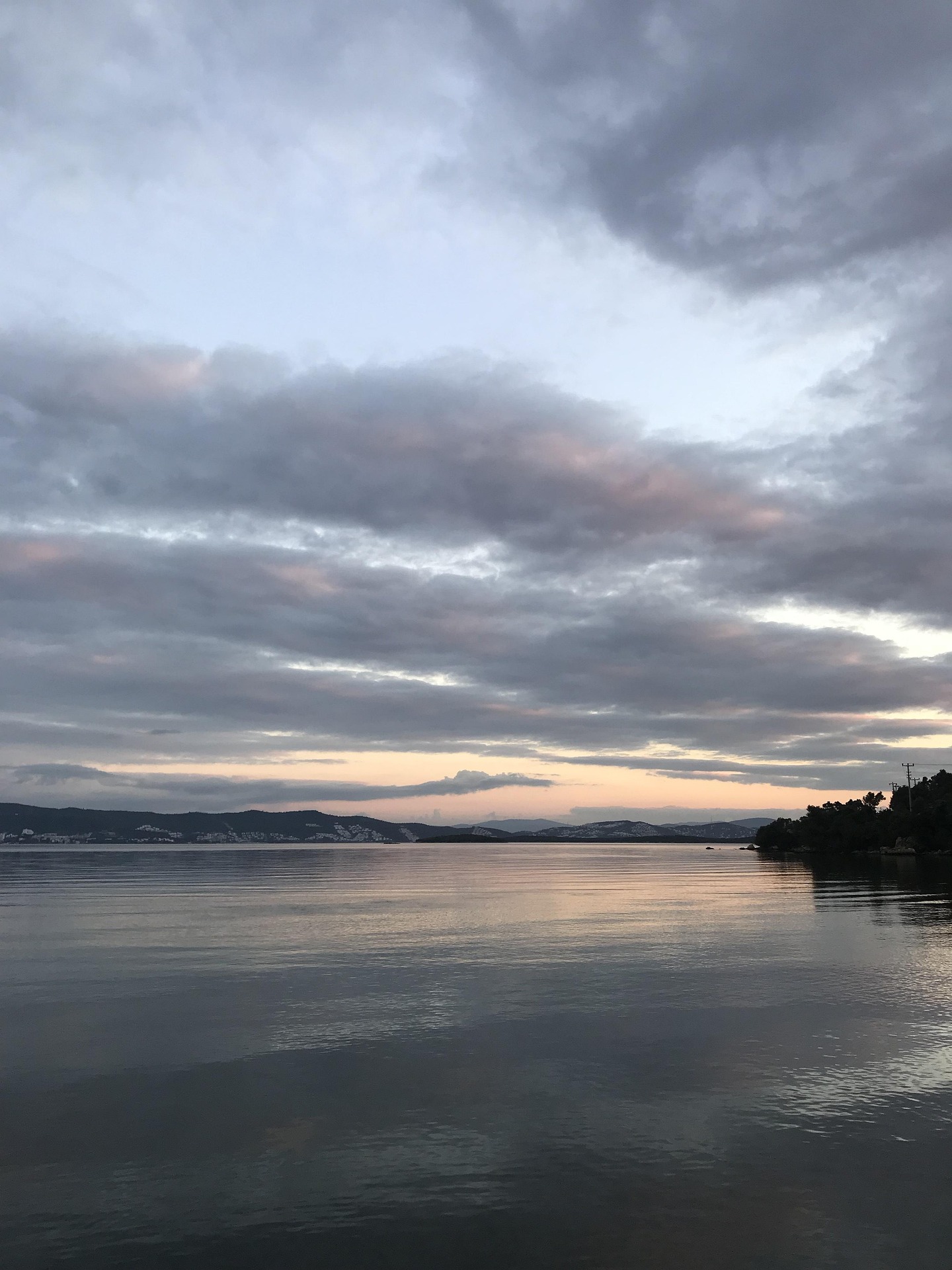 Güzel gökyüzü ve sakin suyla yansıyan doğal bir göl manzarası.